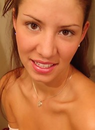 Tara posing in a braless white top